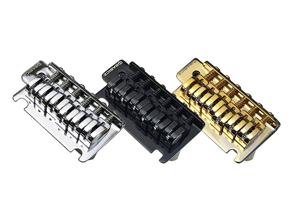 Three Babicz guitar bridges in silver, black, and gold, shown side by side.