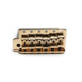 Gold-colored metal guitar bridge assembly with six adjustable saddles arranged in a row on a white background.