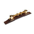 Gold-colored metal bridge with multiple adjustable rings mounted on a rosewood base for string instruments.