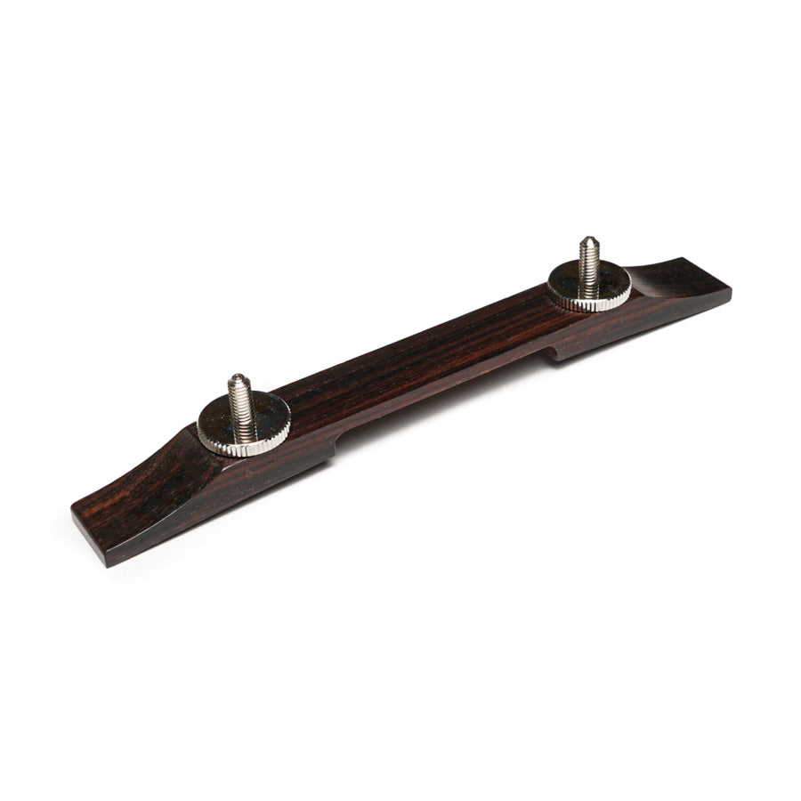 Dark brown wooden guitar bridge part with two metal screws on top against a white background.