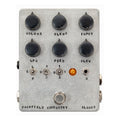 Silver rectangular guitar effects pedal with six black knobs, three toggles, one jack, one footswitch, and an orange indicator light.