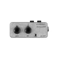 Small metallic audio device with two black control knobs and a 1/4 inch input jack.
