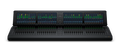 Black audio mixer console with multiple faders, illuminated rotary knobs, push buttons, and large color LCD screens with audio levels.
