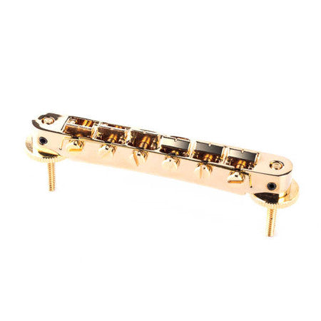 Gold metallic guitar bridge with adjustment thumbwheels and base screws.
