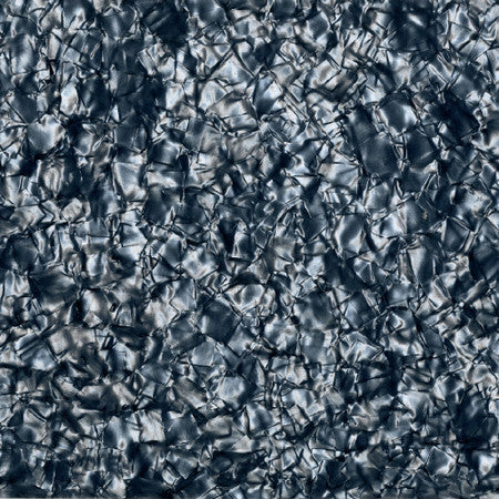 Close-up of a 4-ply grey pearloid pickguard blank material with a textured pattern.