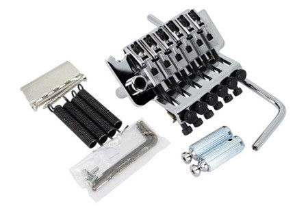 Silver metal guitar tremolo bridge with springs, whammy bar, posts, and hex wrench on a white background.