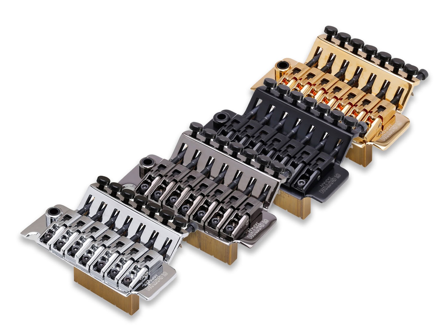 Four guitar locking tremolo bridges in silver, black, dark gray, and gold finishes displayed in a row.