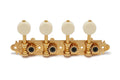 Set of four gold metal mandolin machine heads with cream tuning peg knobs mounted on an engraved plate.