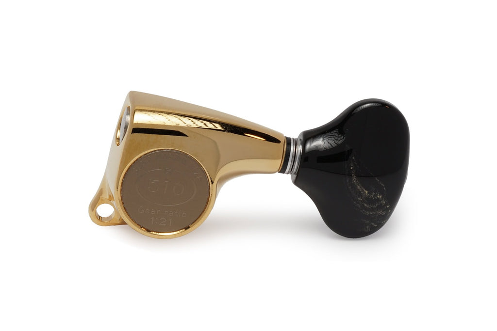 Single gold metal guitar machine head with black tuning knob on a white background.