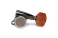 A single black and silver guitar tuning machine head with an orange tuning peg is shown on a white background.