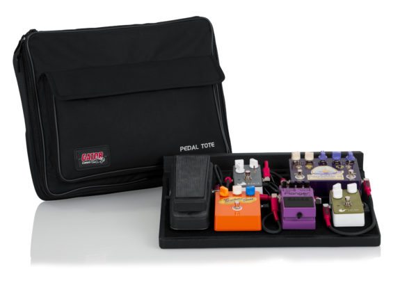 Black pedalboard with multiple effect pedals and a black carrying bag labeled Pedal Tote