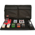 Black soft pedal tote bag with multiple guitar effect pedals arranged on a pedalboard in front of it.