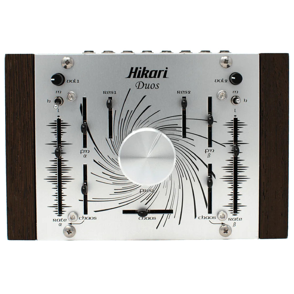 Top view of Hikari Duos synthesizer with multiple knobs, sliders, and switches on a silver metal panel with wooden sides.