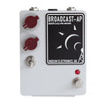 White rectangular electronic pedal with two red knobs, a toggle switch, a footswitch, and input/output jacks.