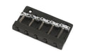 Black and silver metal guitar bridge component with five tuning saddles and springs on a white background.