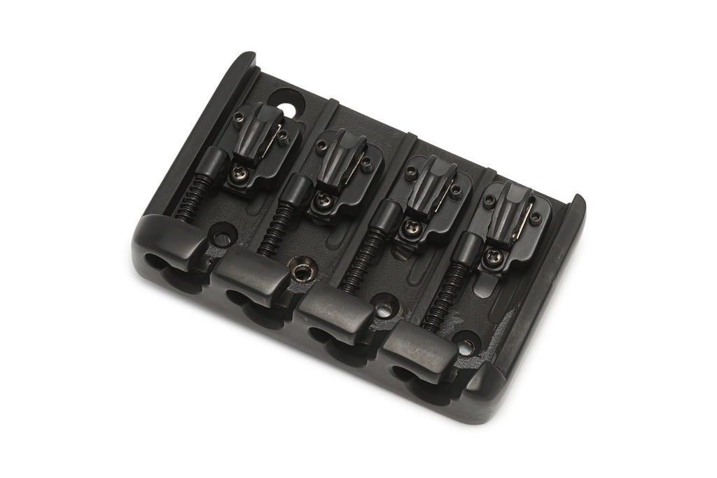 Black metal bass bridge with four adjustable saddles and screws, shown at an angle on a white background.