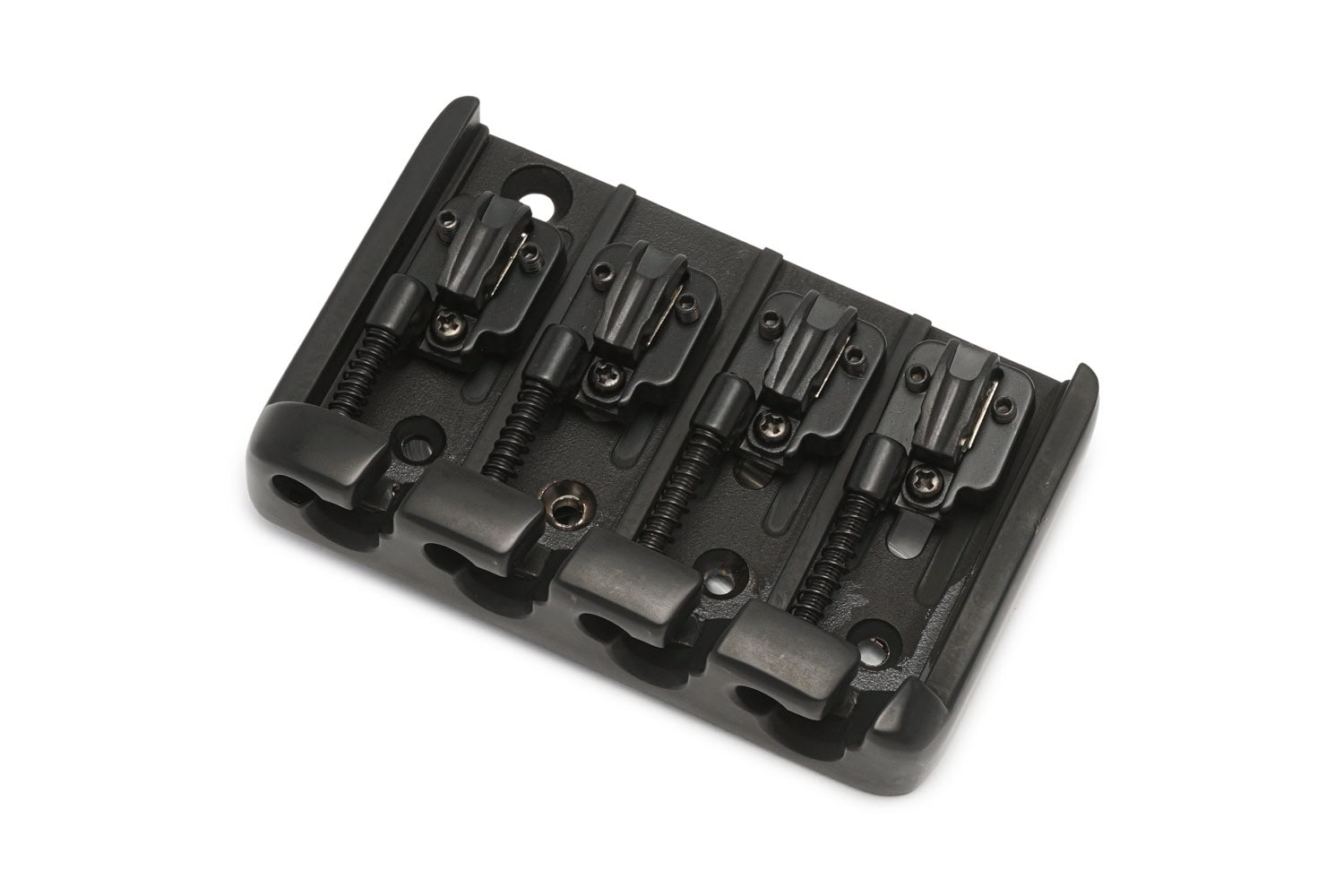 Black metal bass bridge with four adjustable saddles and screws, shown at an angle on a white background.