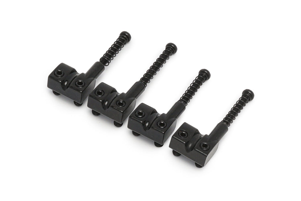 Four black metal bass saddles each with adjustable height screws arranged in a row.