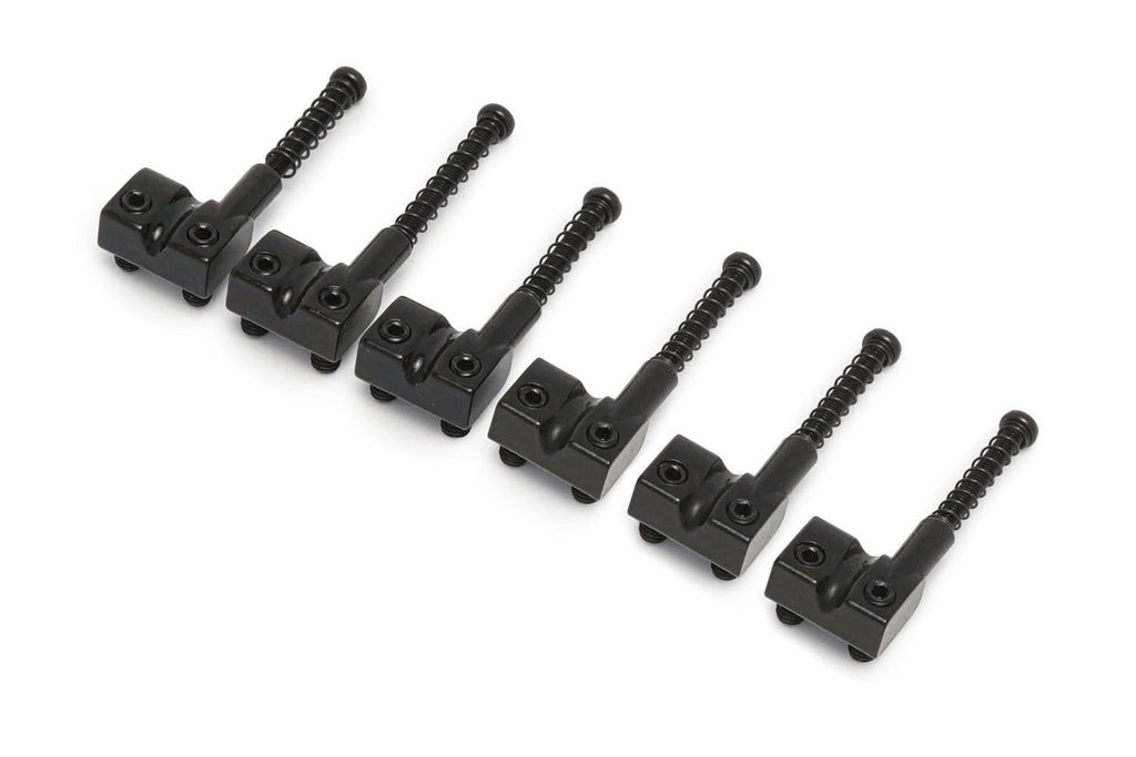 Six black metal bridge saddles each with tension springs and adjustment screws arranged in a line.