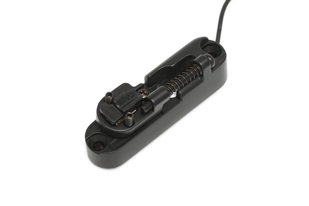 Black single string bridge for bass guitar with attached cable and adjustable components.