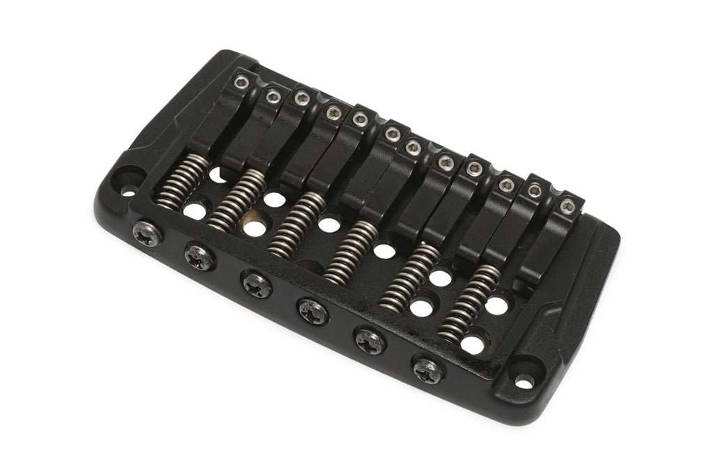 Black metal fixed guitar bridge with six saddle springs and screws on white background.