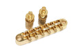 Gold tune-o-matic style guitar bridge with two thumbwheels on a white background