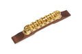 Gold metal guitar bridge mounted on a dark brown wood base against a white background.