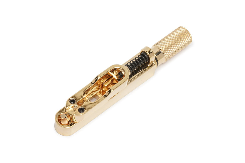 Gold-colored single string guitar bridge with a knurled tuning knob and spring mechanism.