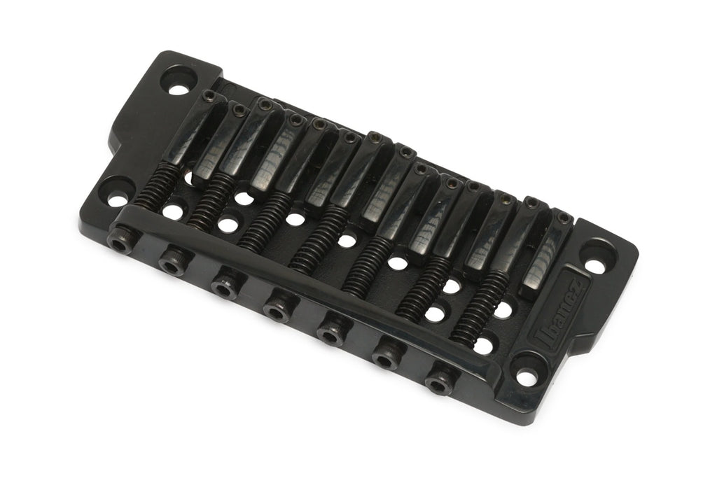 Black metal fixed guitar bridge with seven string saddles and screw adjustments.
