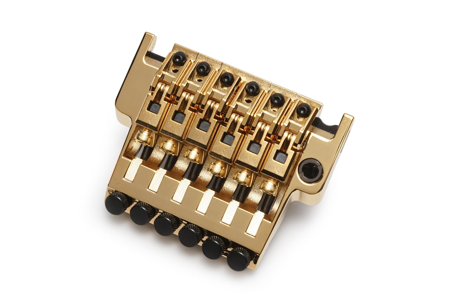 Gold metal tremolo bridge for a 6-string guitar with individual string saddles and adjustment screws.