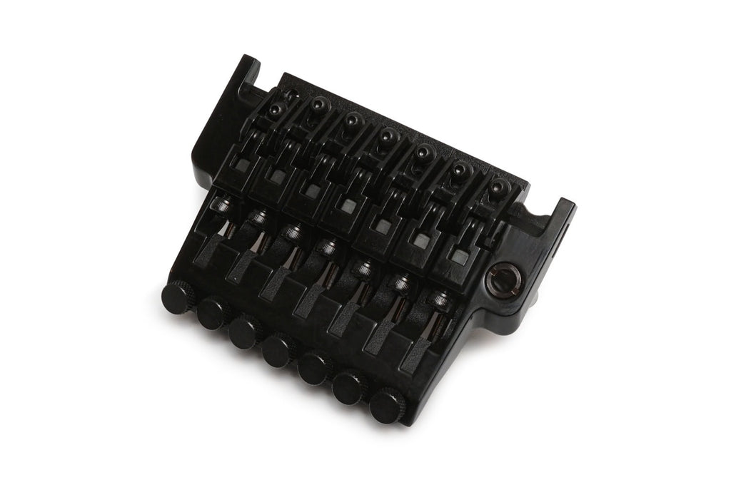 Black guitar tremolo bridge with seven adjustable saddles and screws for string intonation and height.