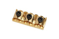 Gold-colored guitar locking nut with three black hex screws and three slots for strings.