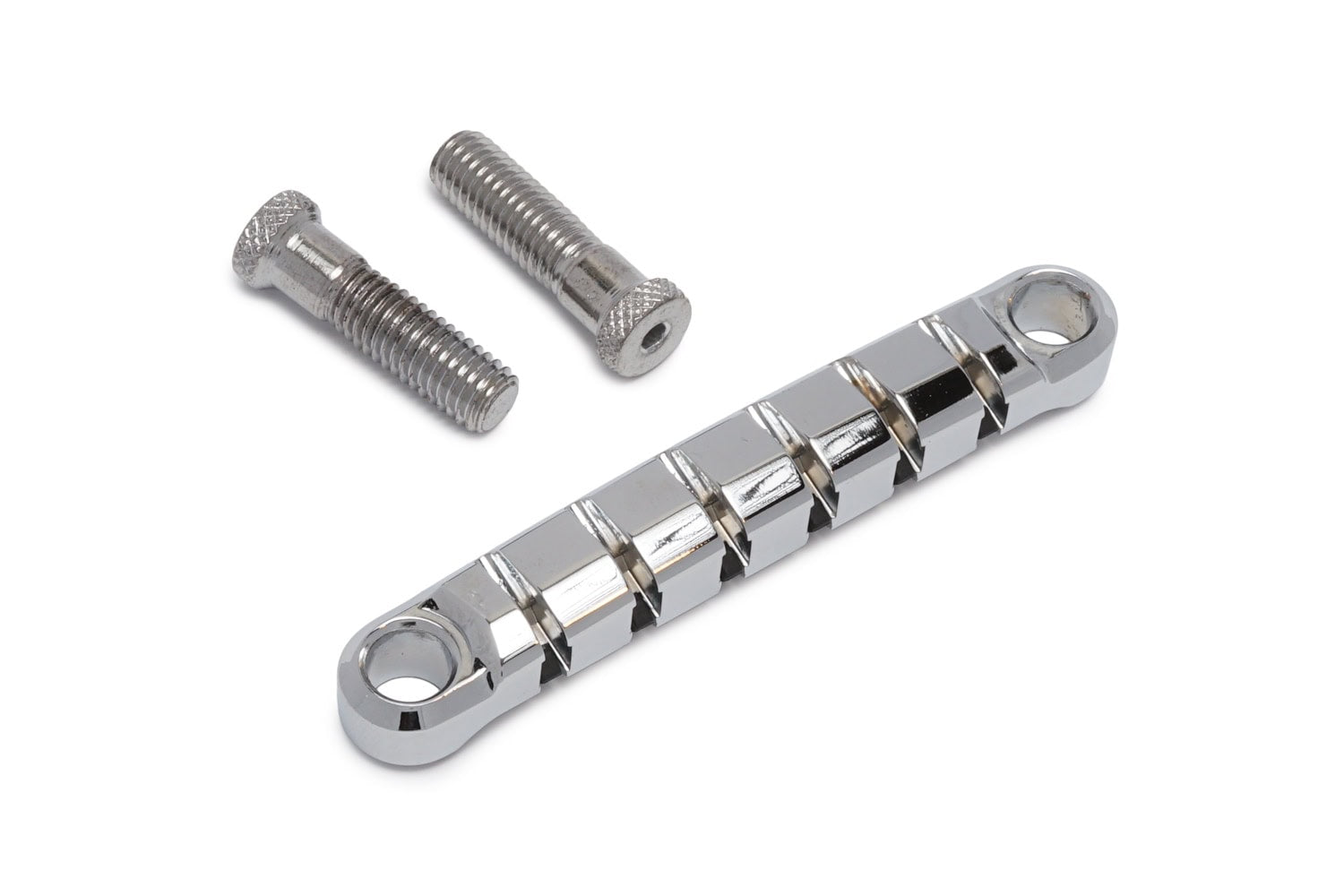 Chrome metal guitar tailpiece with six string slots and two mounting screws on white background.