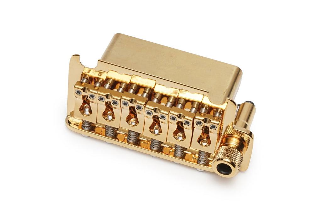 Gold-colored metal guitar bridge with six adjustable saddles and a barrel clamp on the side.
