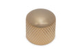 Close-up of a gold-colored knurled metal knob on a white background.