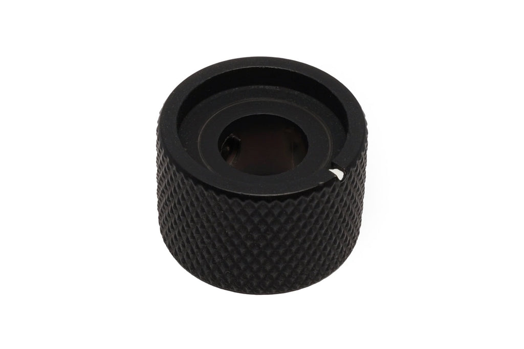 A black textured metal control knob with a small white marker on the side.