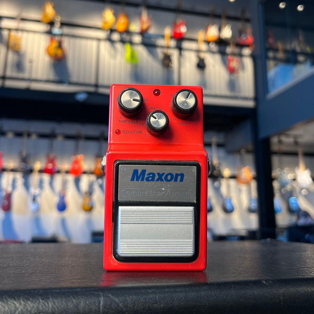 Red Maxon CP9Pro+ compressor/limiter guitar pedal with three control knobs and a footswitch is shown frontally.