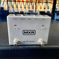 Silver MXR a/b box pedal with two footswitches and five labeled jacks on top side.