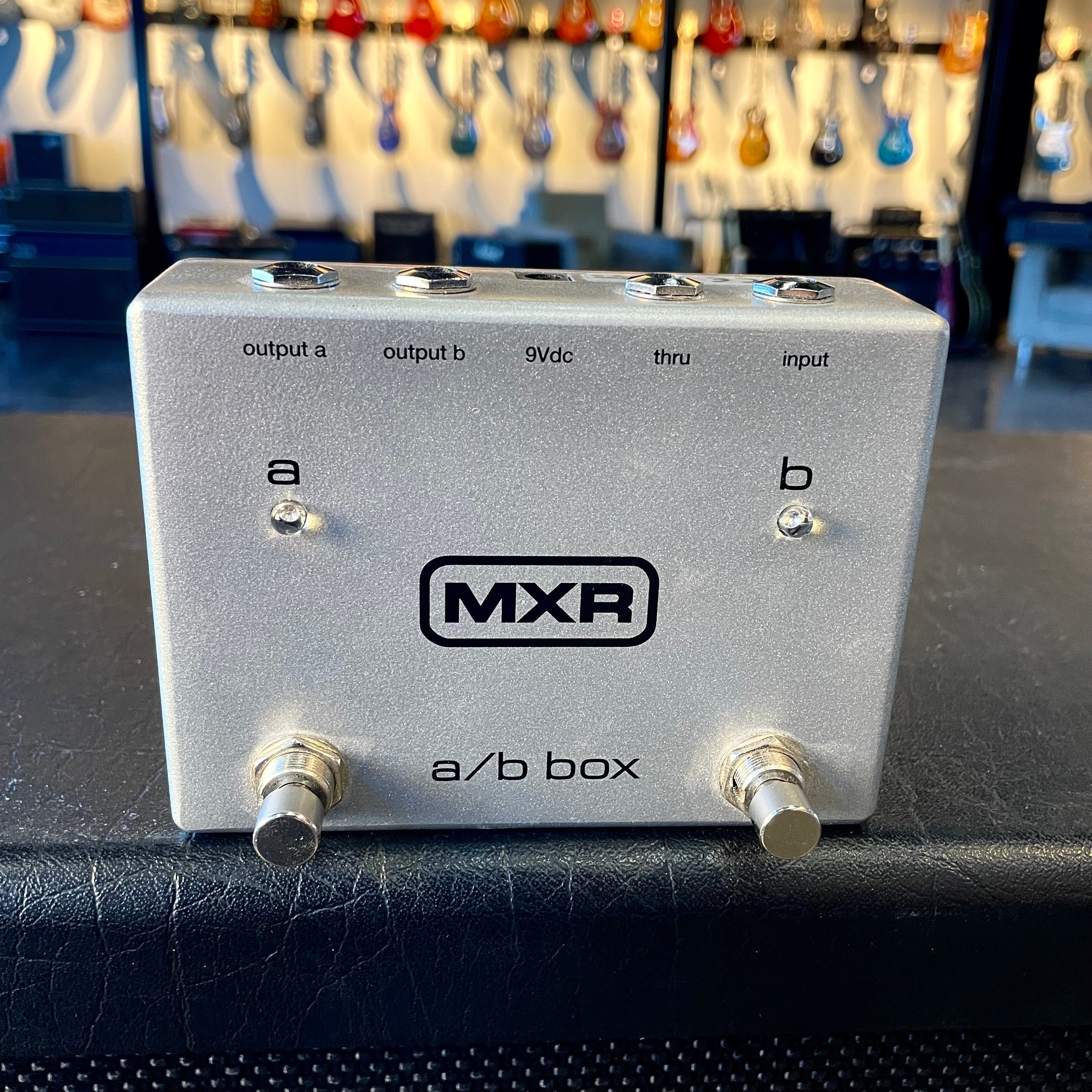 Silver MXR a/b box pedal with two footswitches and five labeled jacks on top side.