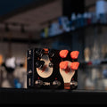 Black JAM guitar effects pedal with knobs, footswitches, toggle switch and light bulb graphics.