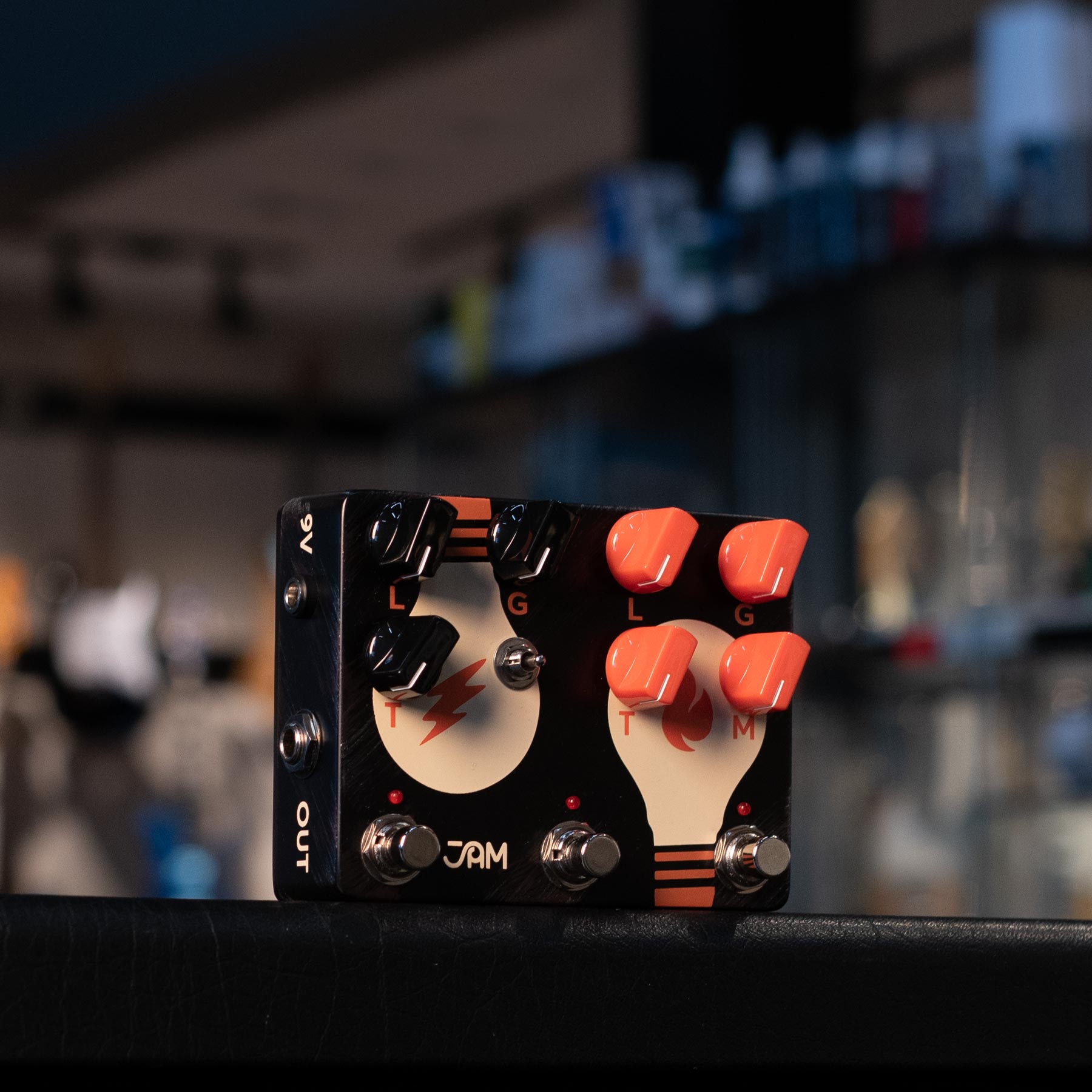 Black JAM guitar effects pedal with knobs, footswitches, toggle switch and light bulb graphics.