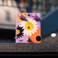 A purple guitar effects pedal with flower graphics, two purple knobs, a toggle switch, and a footswitch on front.