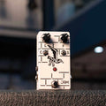 White guitar effects pedal with seagull illustration, two knobs, two toggle switches, and a footswitch.