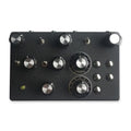 Black rectangular device with multiple silver knobs, toggle switches, and push buttons on its surface.