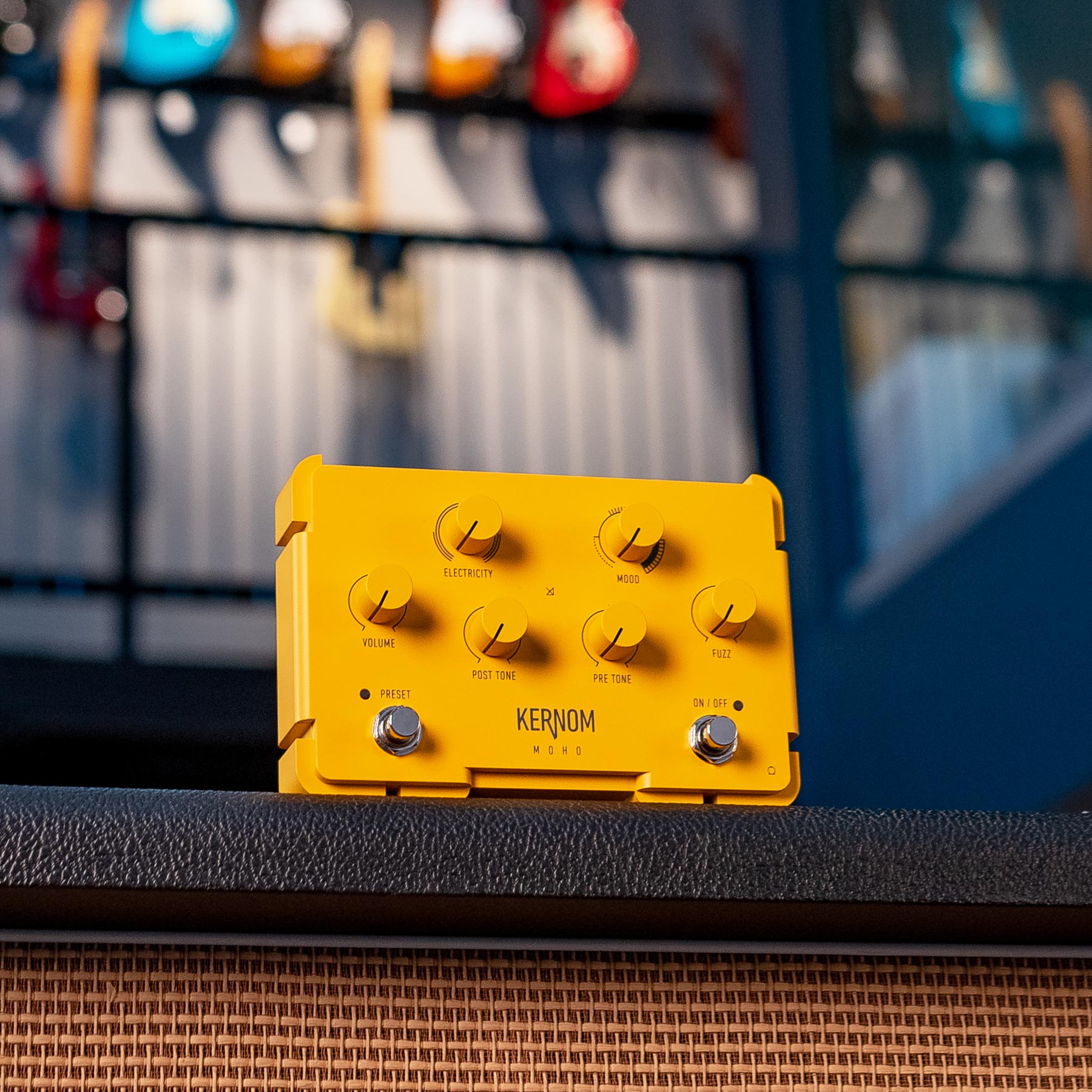 Yellow guitar effects pedal with six knobs and two footswitches on a black surface.