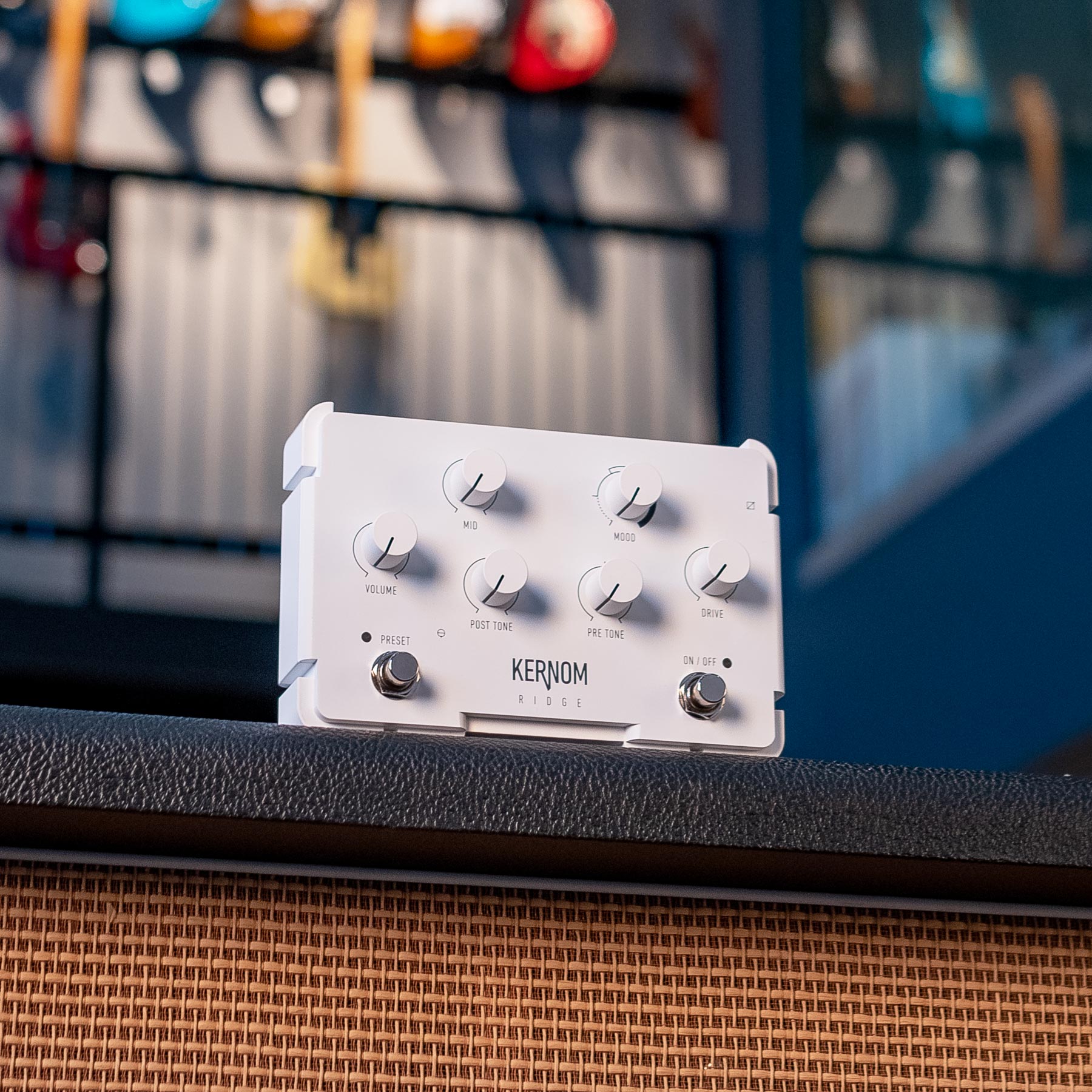White guitar effect pedal with six control knobs and two footswitches labeled KERNOM RIDGE placed on a textured surface.