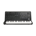 Black analog synthesizer with keyboard, multiple knobs, switches, and patch points on its control panel.