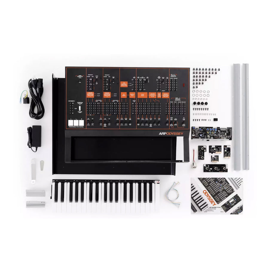 Disassembled electronic keyboard synthesizer kit with control panel, keyboard, cables, components, and manual arranged on white background.