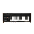 Front view of a black and wooden keyboard synthesizer with white and black keys and various colored controls and buttons