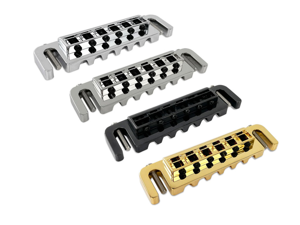 Four guitar bridges in metallic silver, black, and gold finishes with adjustment screws.